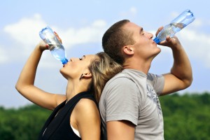 man and woman drinking bottled water